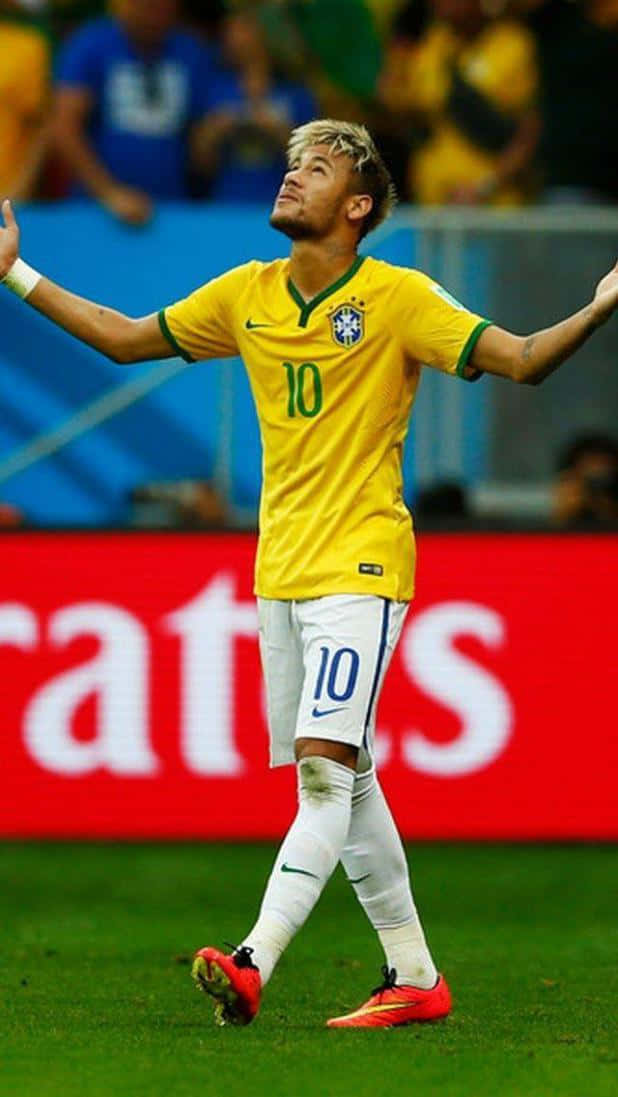 Neymar 桌布 壁紙 — 巴西足球運動員尼馬身穿黃色10號球衣，在球場燈光下於綠色草地上張開雙臂慶祝。