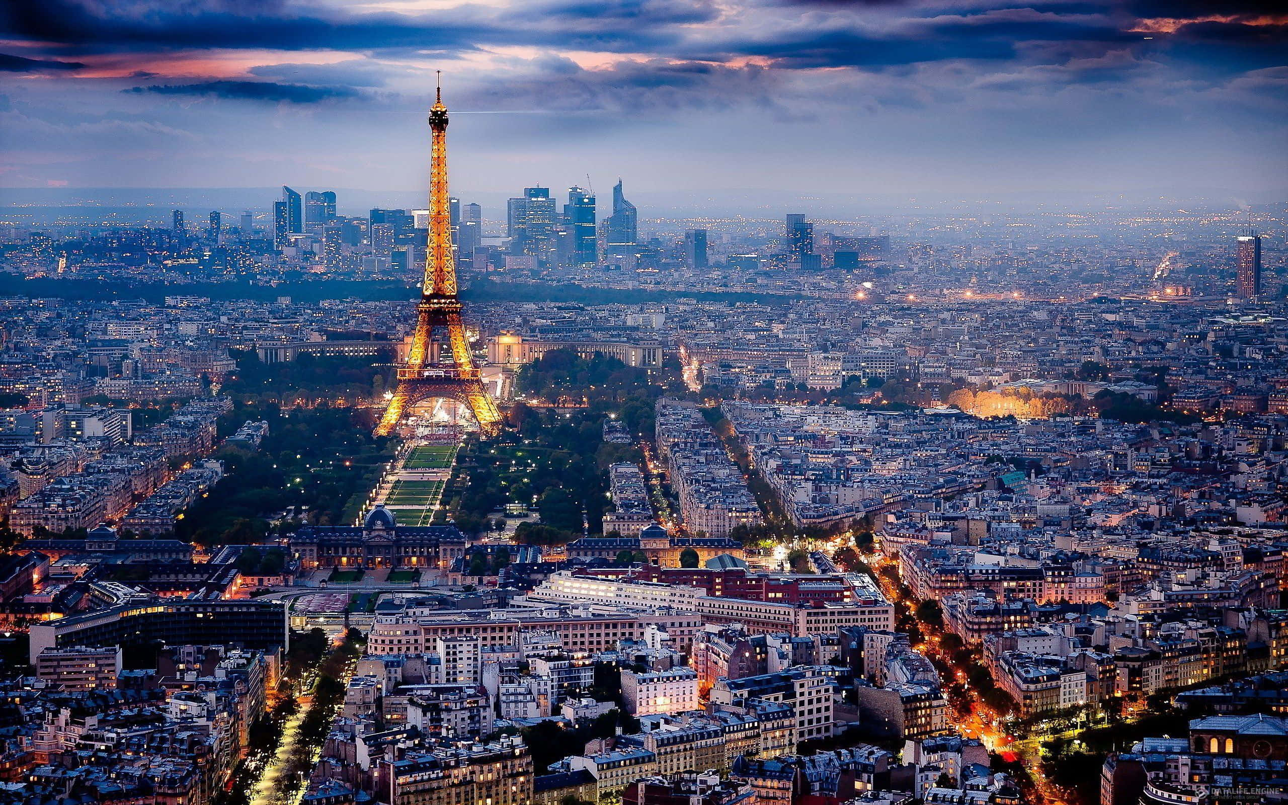 french 桌布 壁紙 — 巴黎天際線在黃昏時分，艾菲爾鐵塔在戲劇性的紫色天空下閃耀著金色光芒。