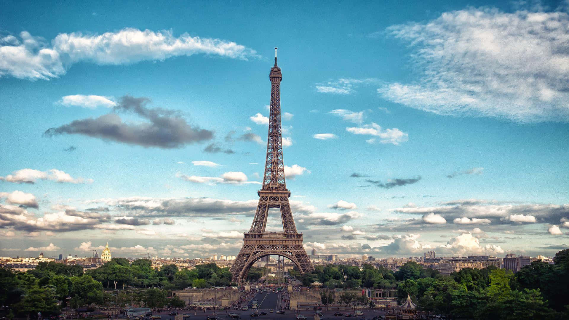 Eiffel Tower 桌布 壁紙 — 巴黎的艾菲爾鐵塔在點綴著蓬鬆白雲的鮮豔藍天下高高聳立。