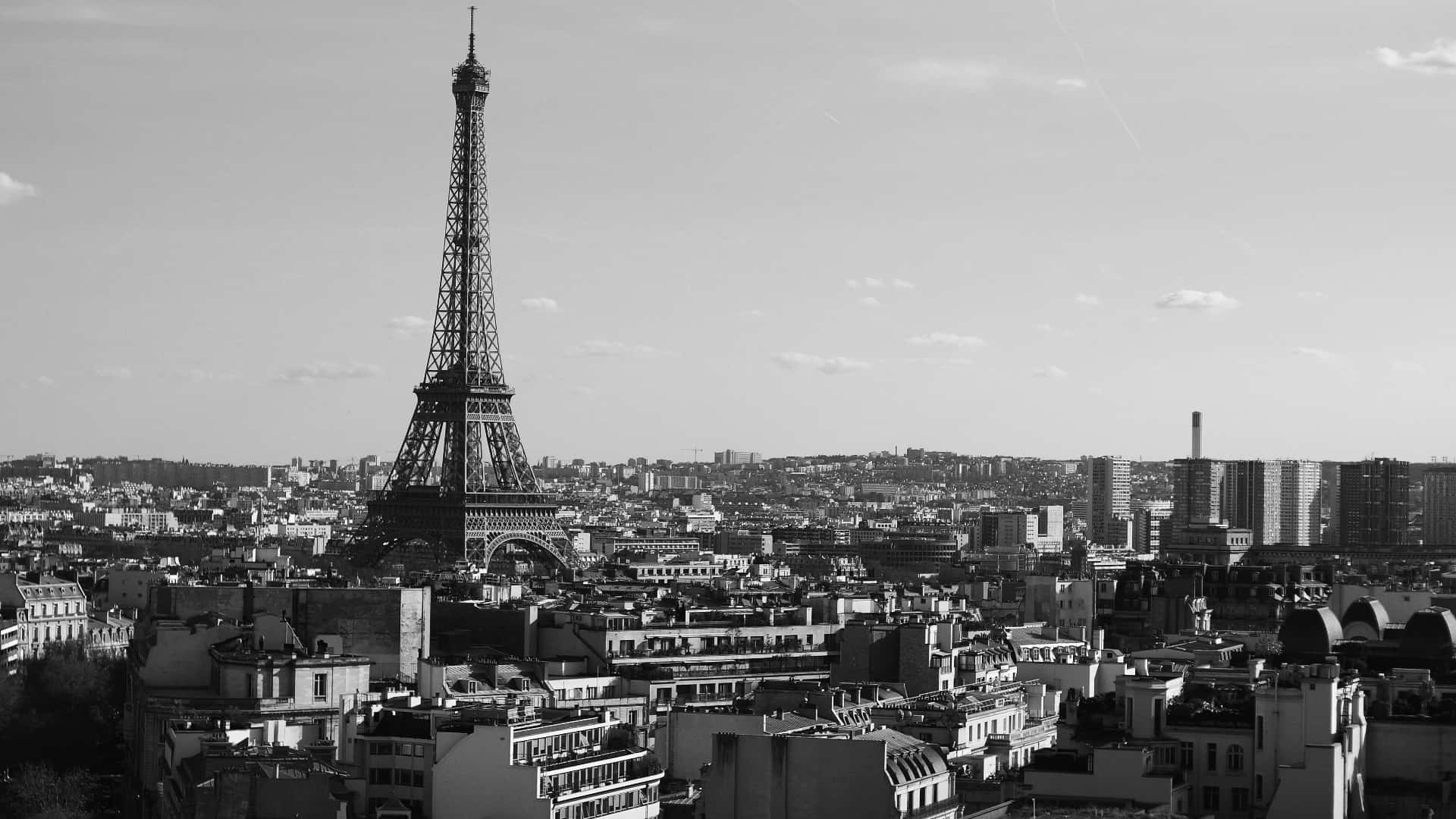 Black And White Cityscape 桌布 壁紙 — 巴黎的黑白航拍圖，展示艾菲爾鐵塔在部分多雲的天空下，從密集的城市景觀中升起。