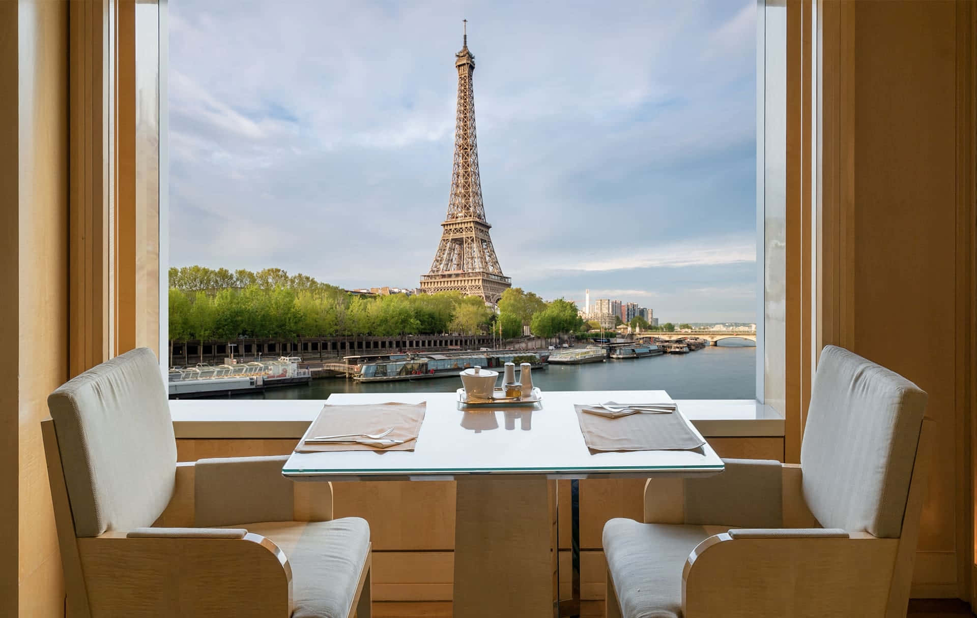 french 桌布 壁紙 — 巴黎酒店房間內，現代二人餐桌套裝，透過大窗戶可俯瞰艾菲爾鐵塔和塞納河。