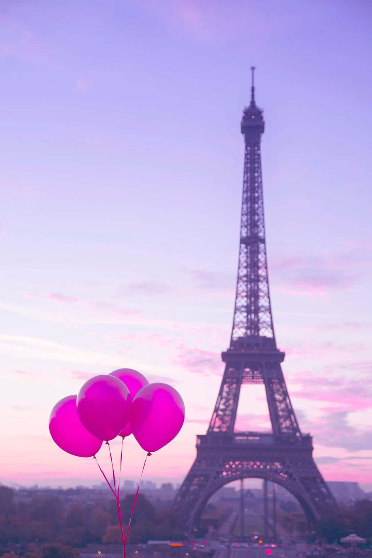 日落時粉紅色氣球漂浮在艾菲爾鐵塔附近。