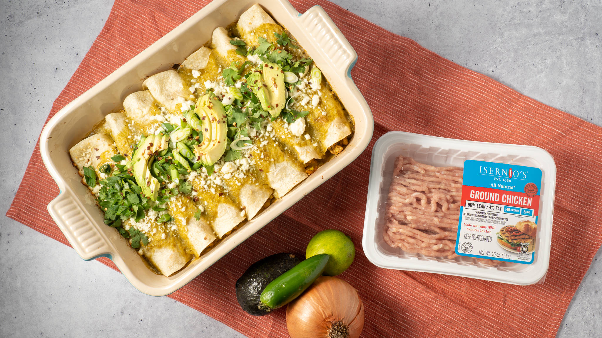 布上擺放的 enchiladas 及配料 壁紙 — 新鮮出爐的雞肉玉米餅，盛載於陶瓷碟中，上面鋪有牛油果、芫荽和芝士，旁邊放有一包免治雞肉和新鮮食材。