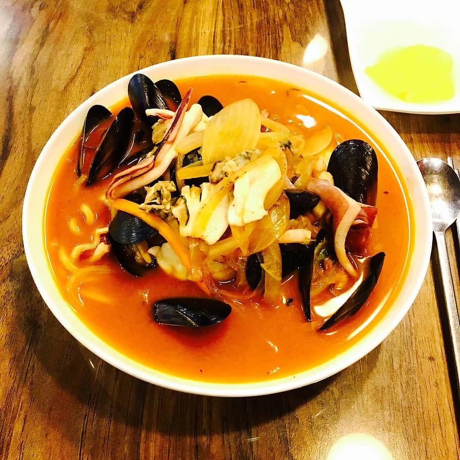 木桌上的一碗青口和魷魚海鮮燉菜