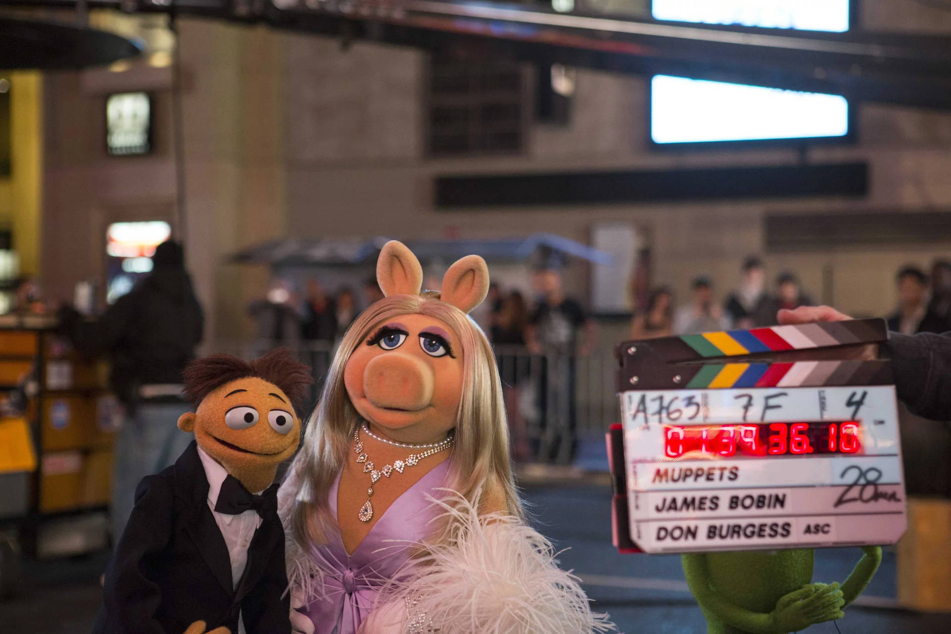 Piggy 和 Kermit 在電影佈景中拿著場記板。