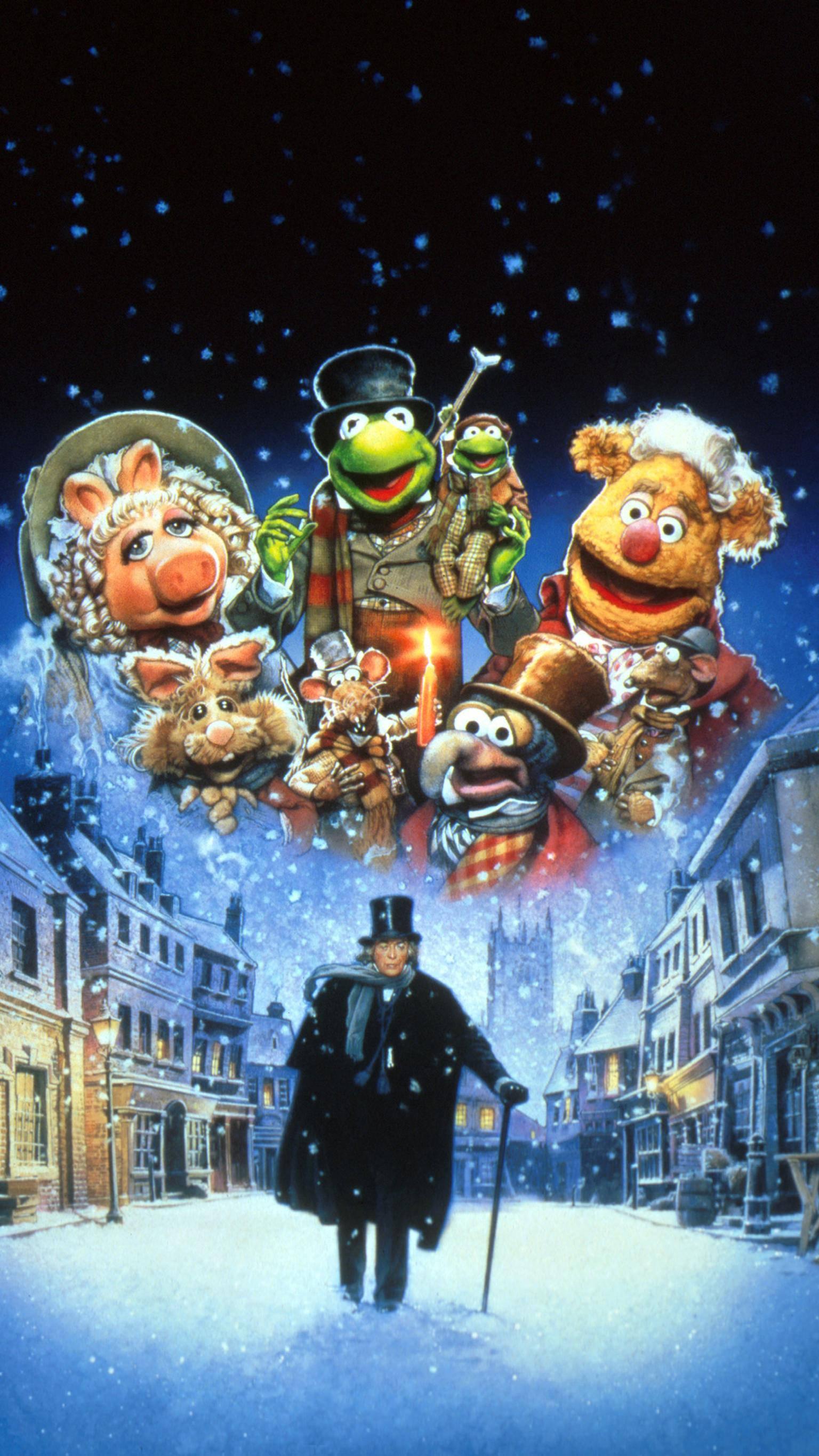 《布偶秀：聖誕頌》中的史古基 壁紙 — Muppet 角色愉快地漂浮在白雪覆蓋的維多利亞式街道上方，一名男子在飄雪下行走於下方。