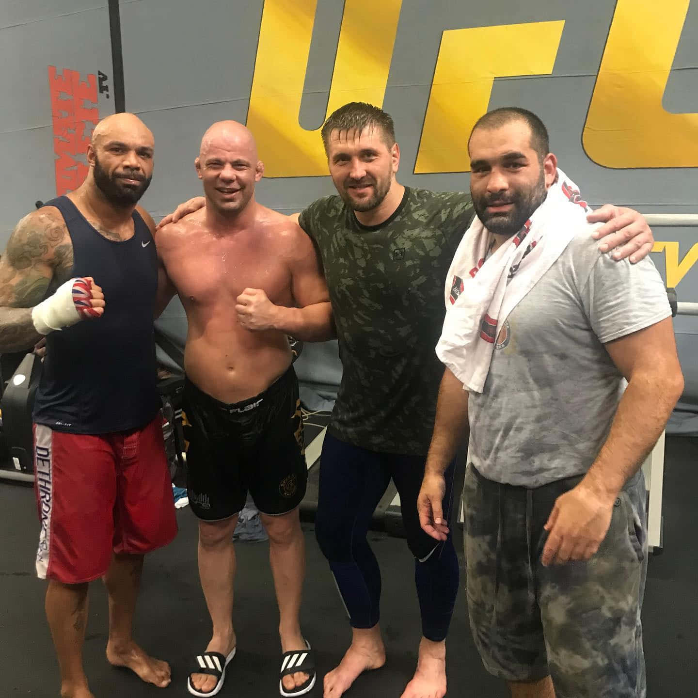 四位男性拳手在UFC健身室訓練後一起擺姿勢。