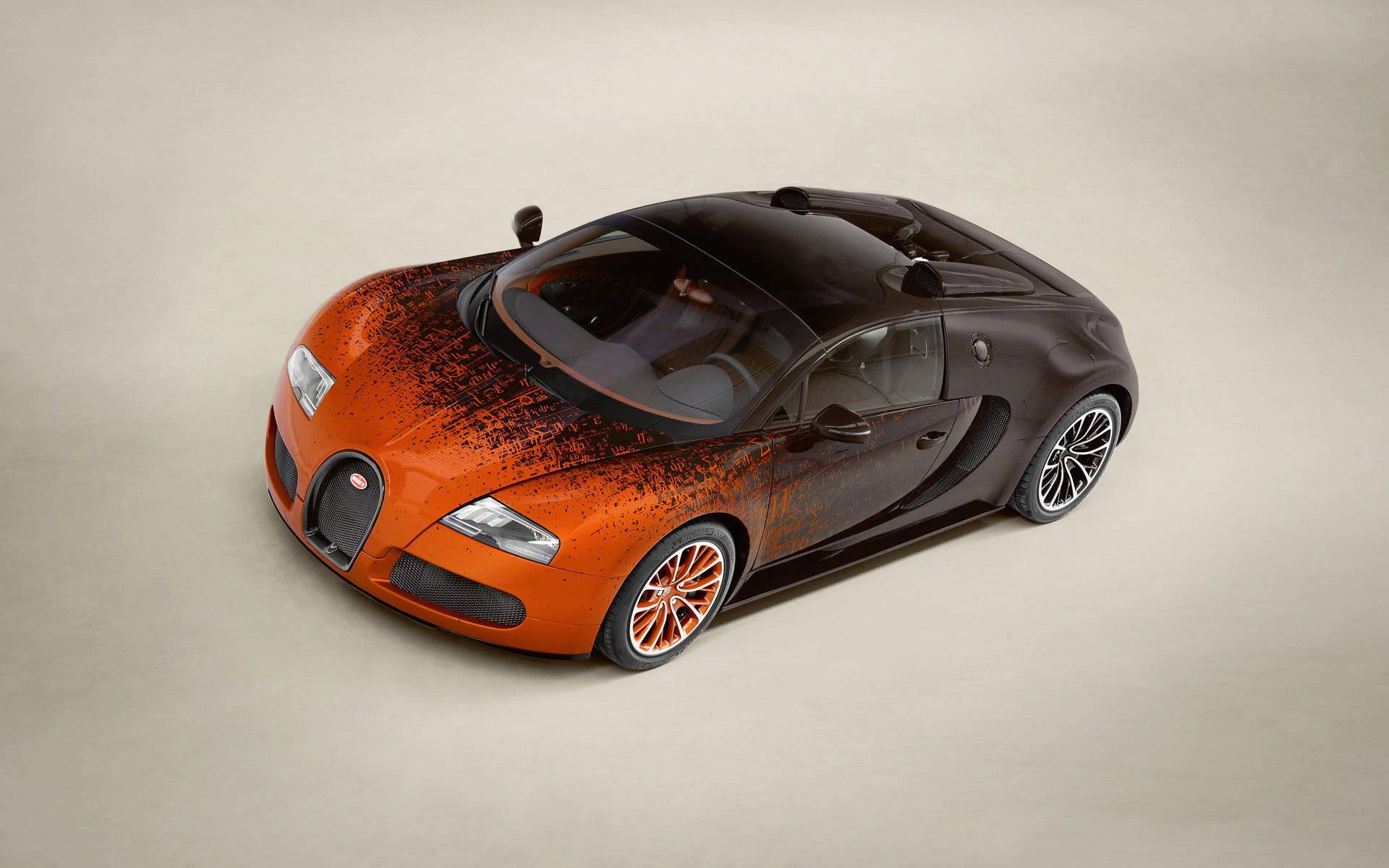 橙色和黑色的Bugatti Veyron超級跑車在攝影棚燈光下。