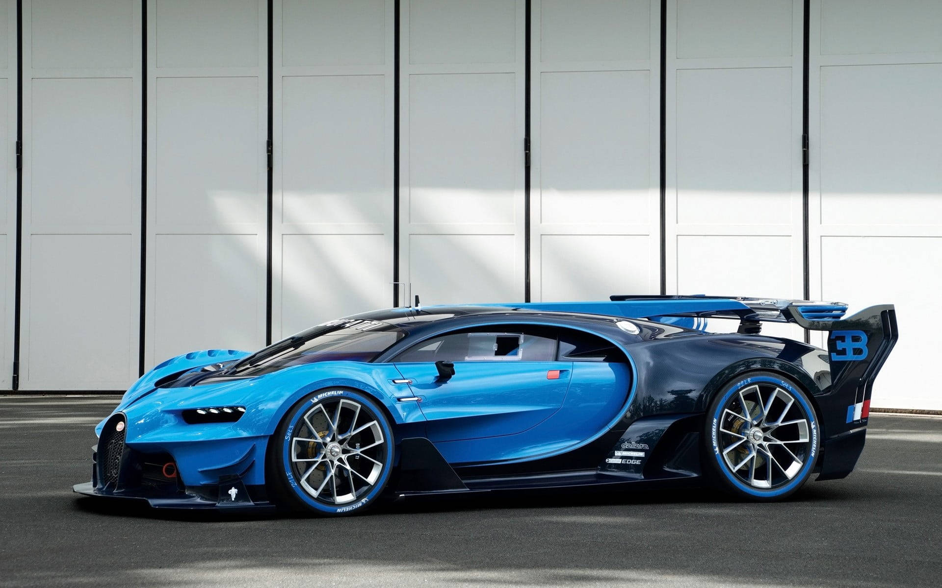 一架藍黑 Bugatti 超跑停泊在白色車庫前。