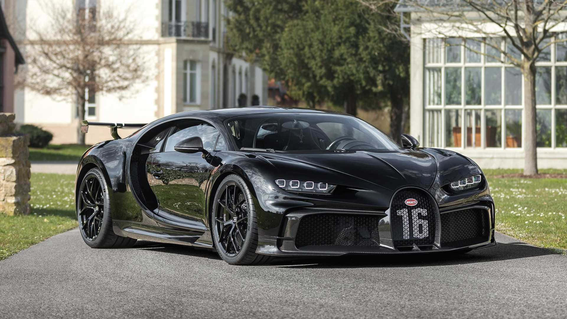黑色Bugatti Chiron Super Sport 300+打開車門停泊在房屋附近的車道上。