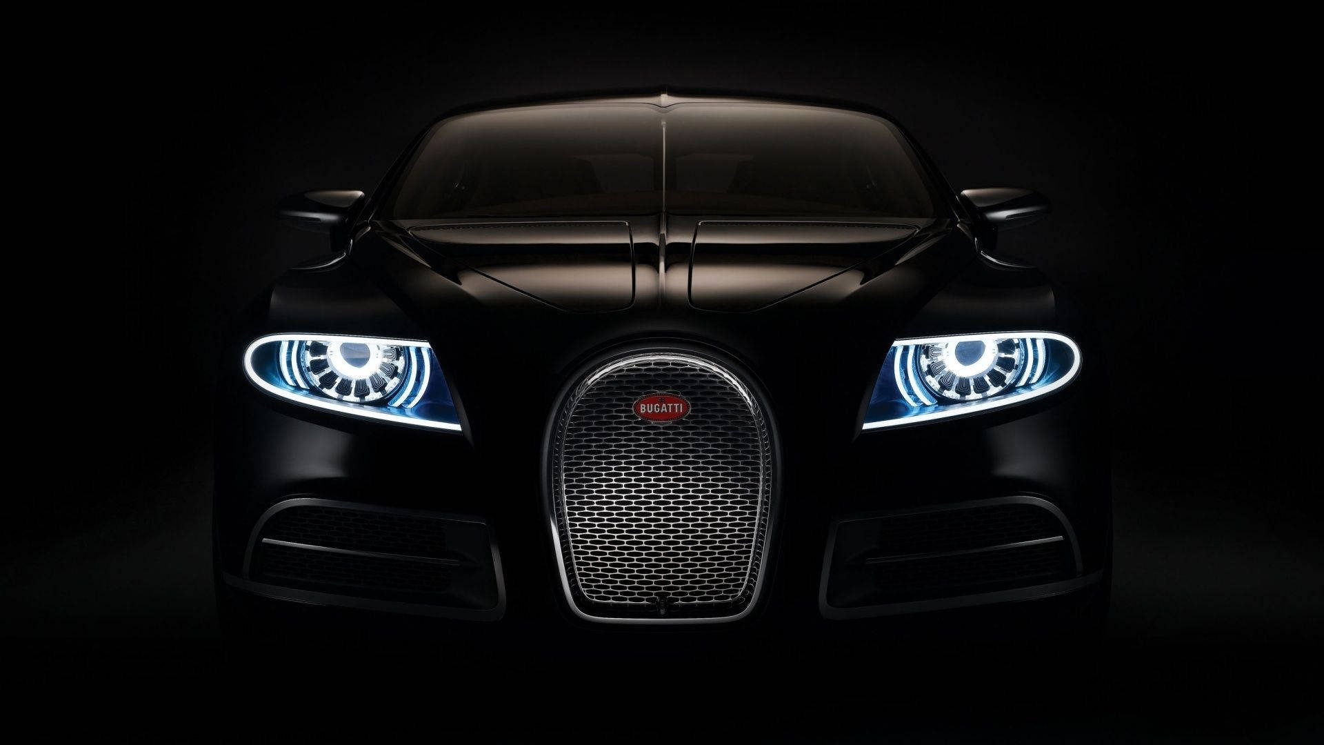 黑色Bugatti超級跑車在黑暗中車頭燈發光的前視圖。