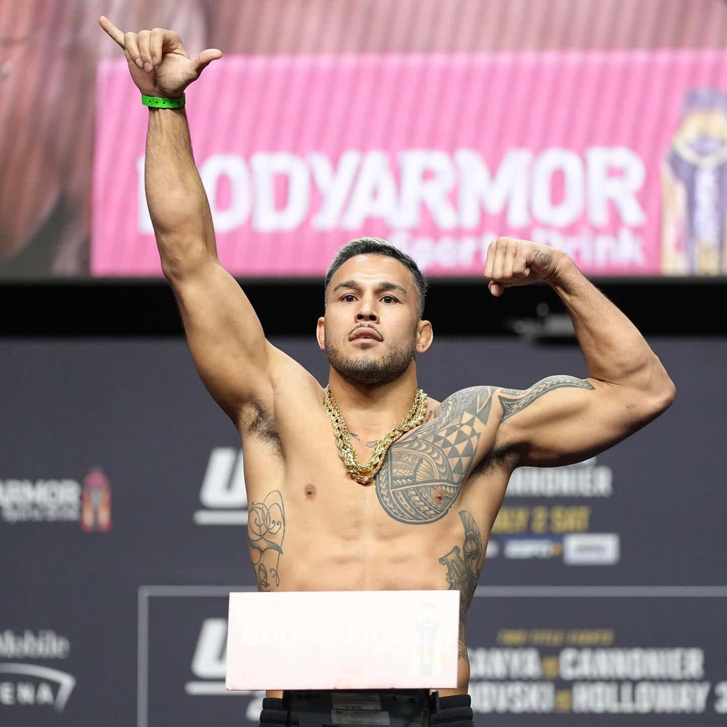 格鬥家在UFC稱重活動中繃緊肌肉並舉手