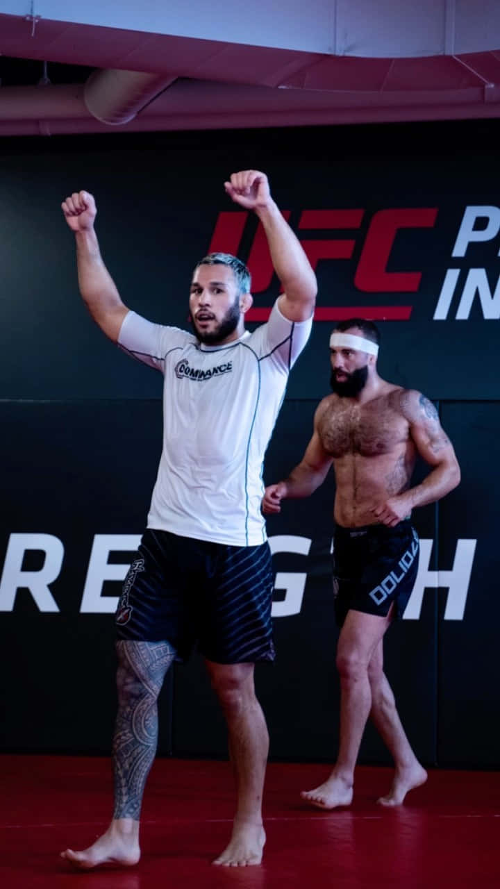 MMA戰士在UFC健身房高舉拳頭慶祝勝利。
