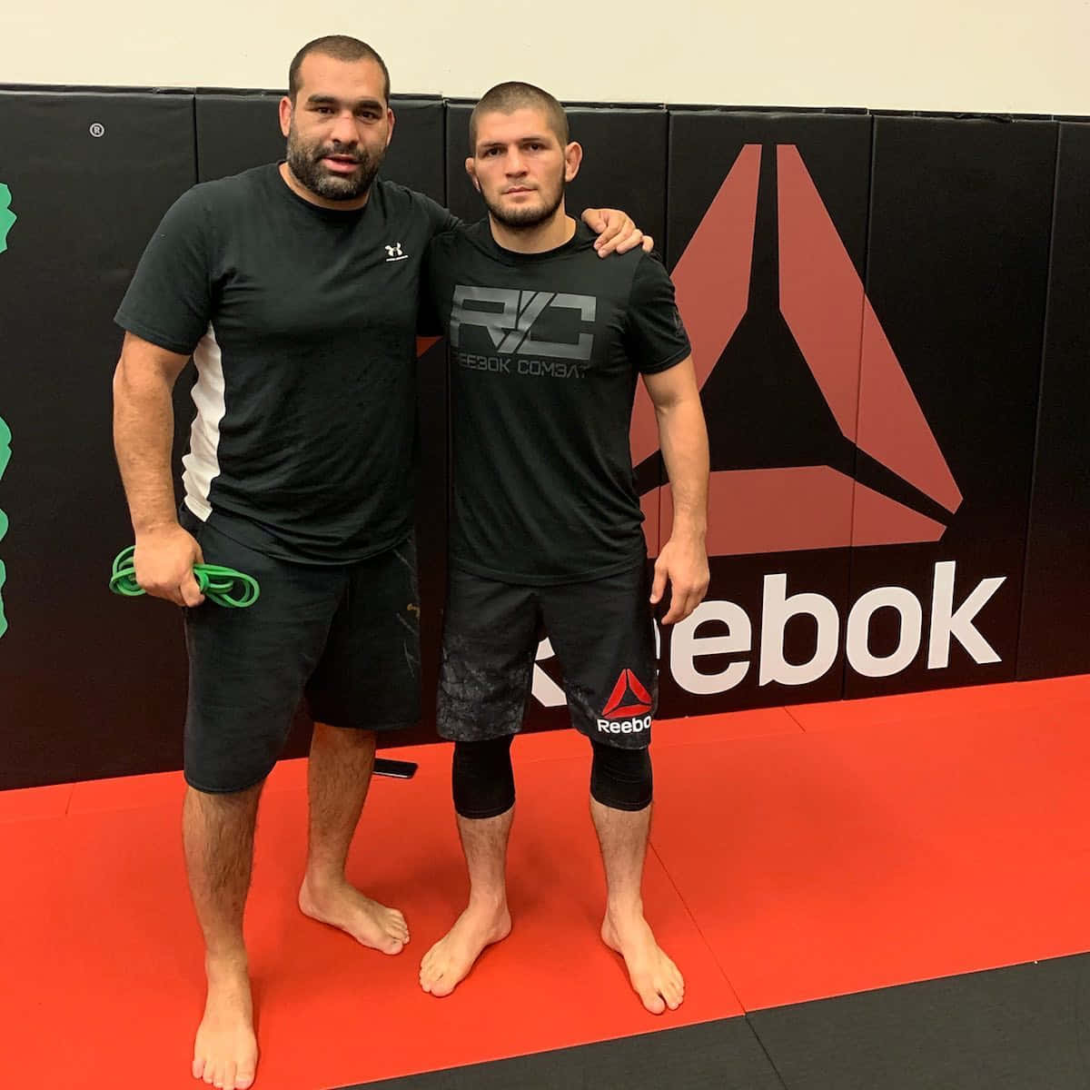 兩名身穿Reebok裝備的男性拳手在紅色健身墊上擺姿勢。