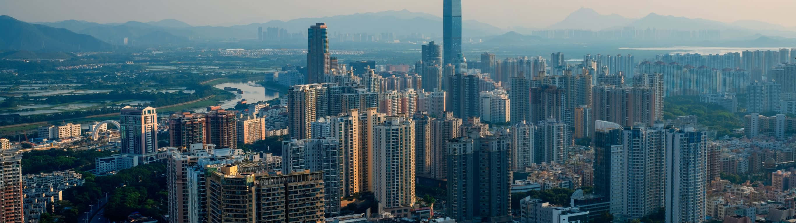 日落時分現代城市的全景視圖，背景是山脈。