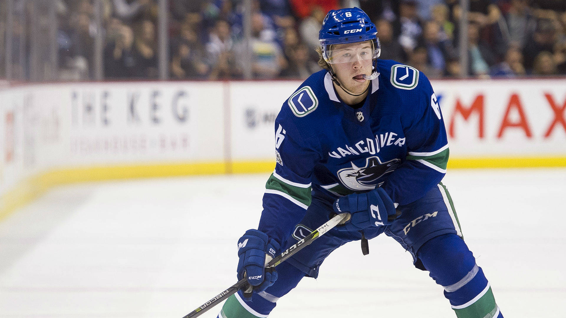 布羅克·布瑟對戰埃德蒙頓油人隊 壁紙 — 一名身穿溫哥華加人隊（Vancouver Canucks）藍色球衣的冰球運動員，在冰上專注而激烈地滑行。