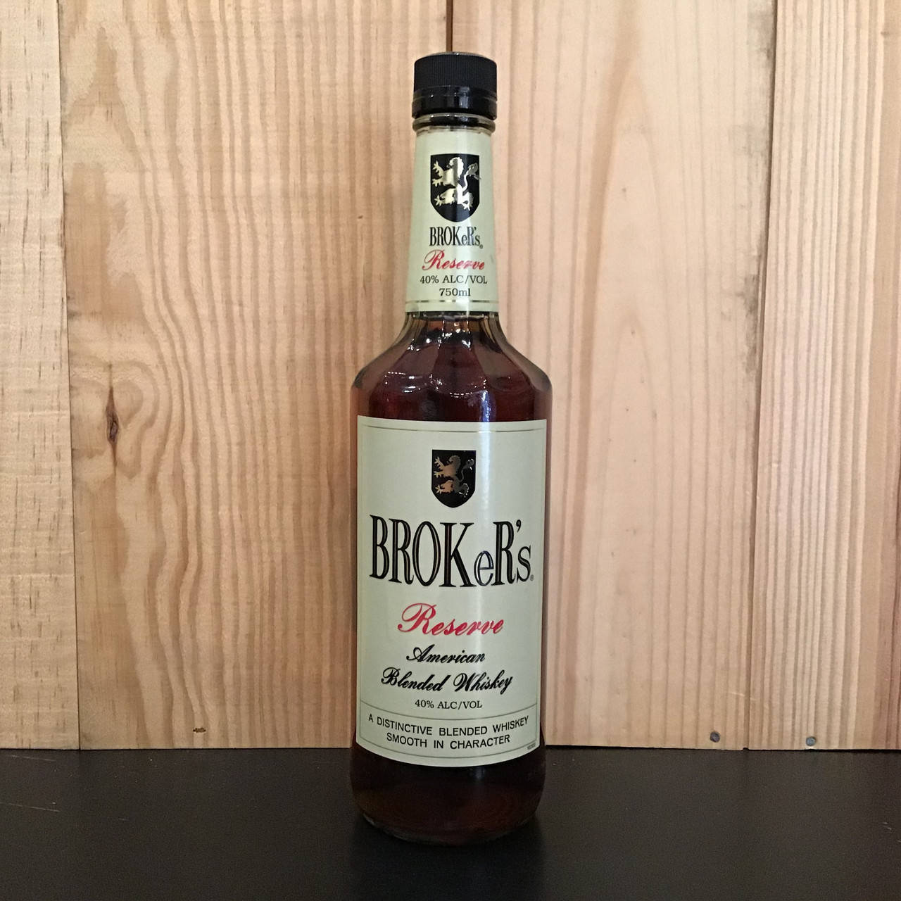 深色表面上的一瓶 Broke's Reserve American Blended Whiskey 與木紋面板。