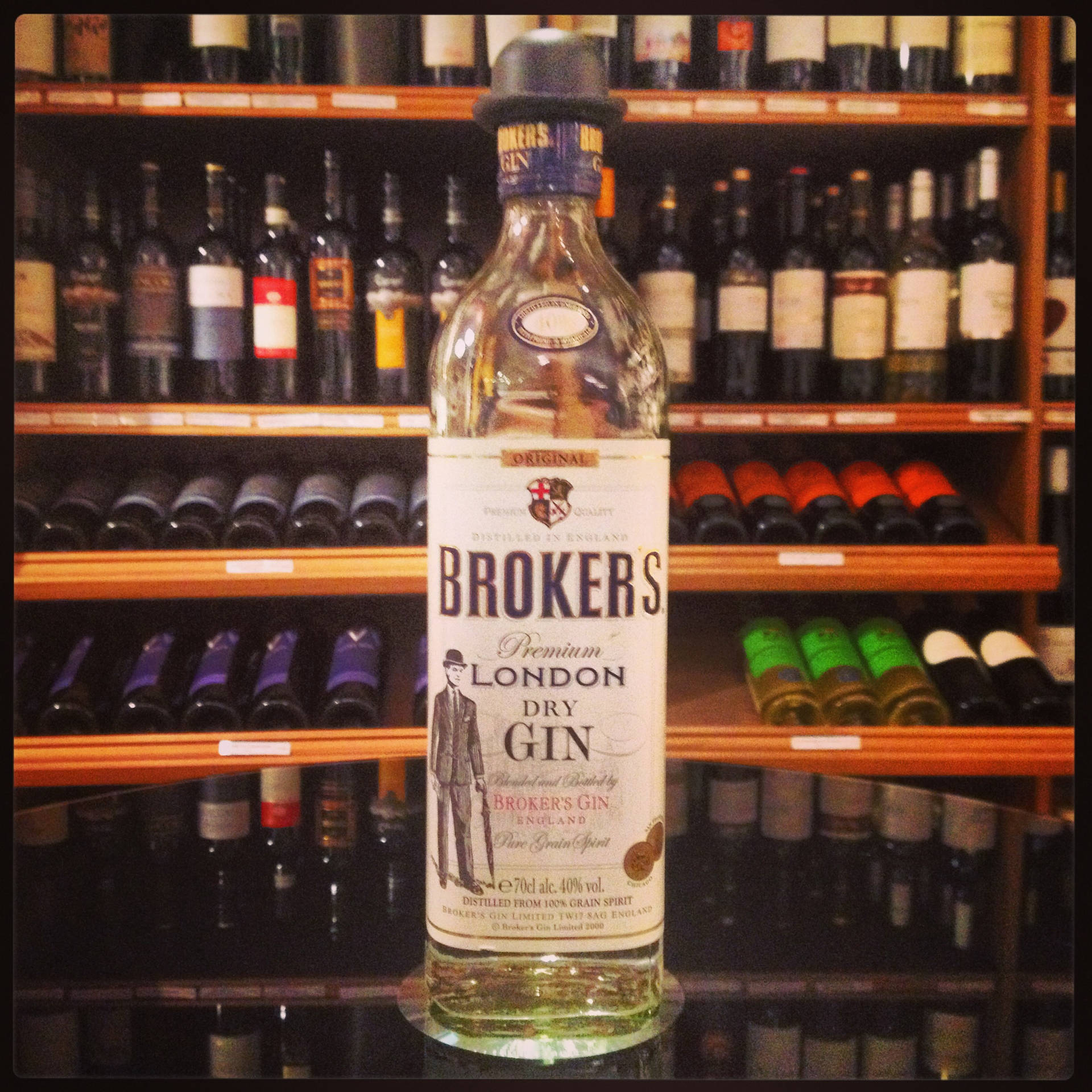 在酒吧架上展示的 Brokers 琴酒瓶，後面有葡萄酒瓶。