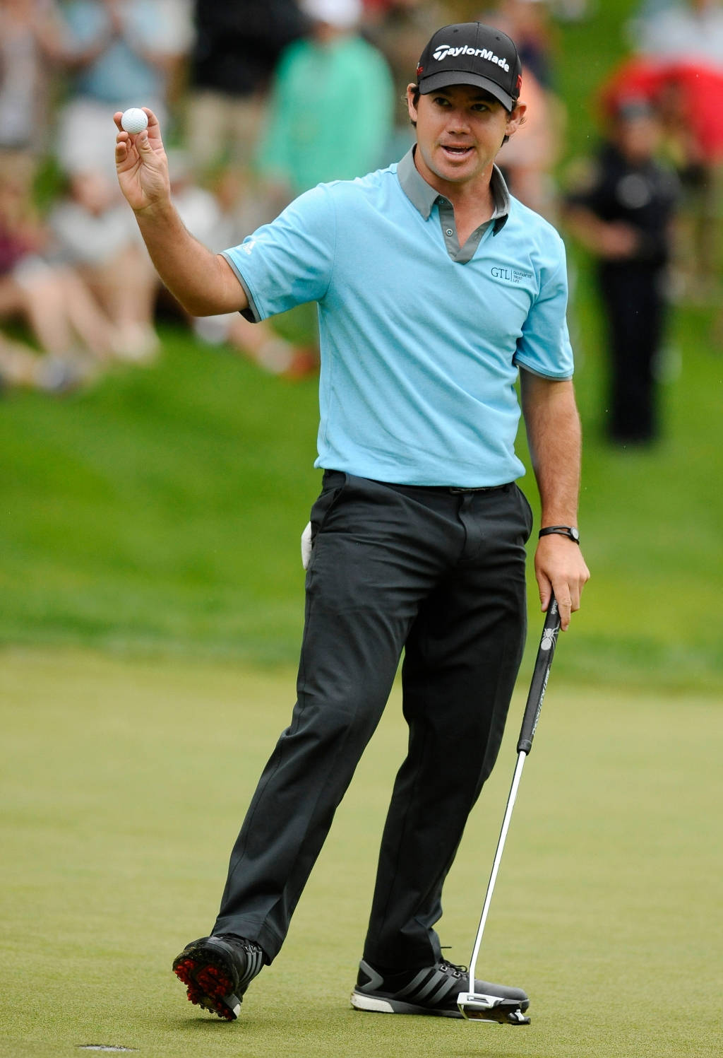 布萊恩·哈曼職業高爾夫球手全身照 壁紙 — 高爾夫球手Rory McIlroy在翠綠的高爾夫球場上慶祝，手持高爾夫球和推桿。