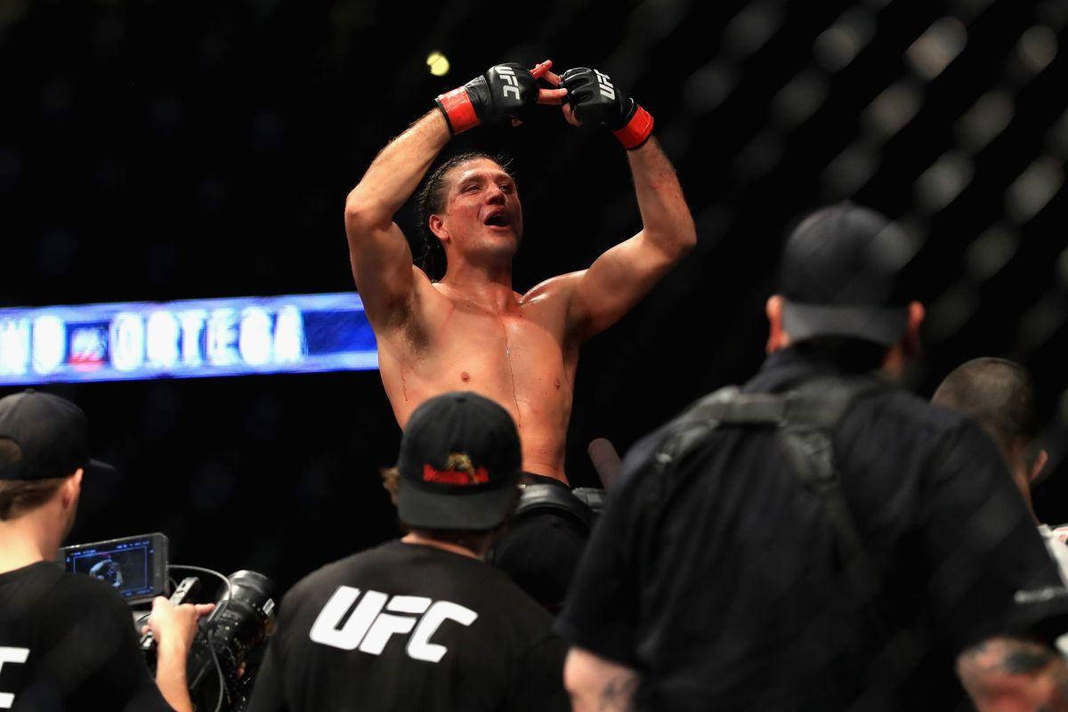 UFC拳手在八角籠內高舉拳頭慶祝勝利。