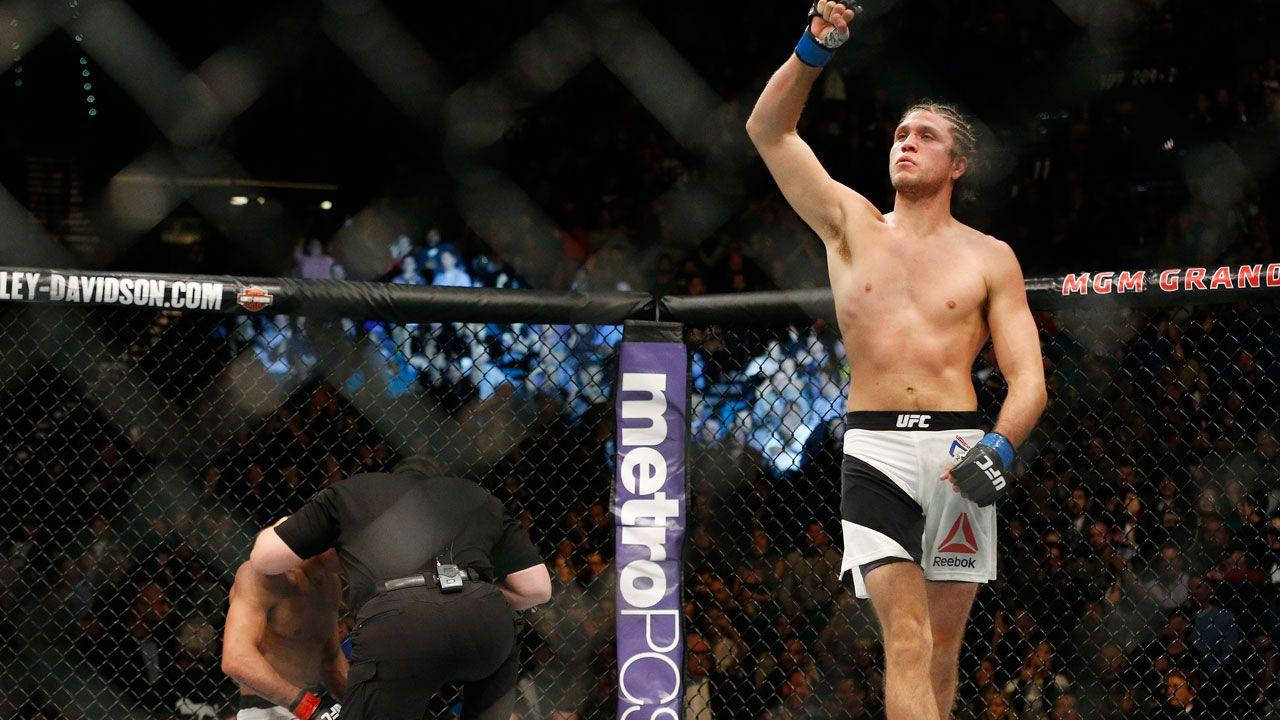 UFC拳手在八角籠內慶祝勝利，觀眾歡呼
