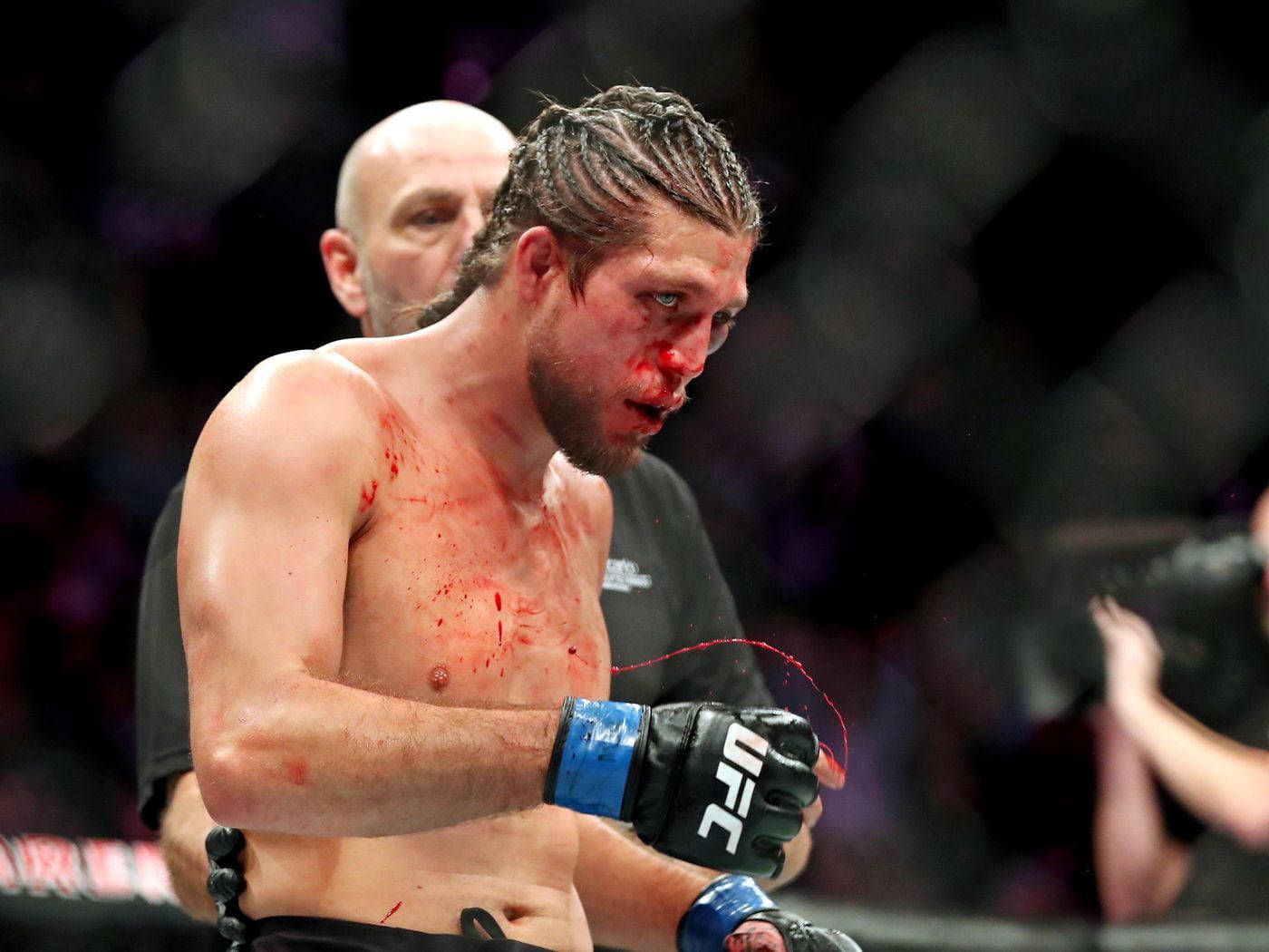 一名血跡斑斑的MMA拳手在UFC比賽中遭受打擊後在八角籠中。