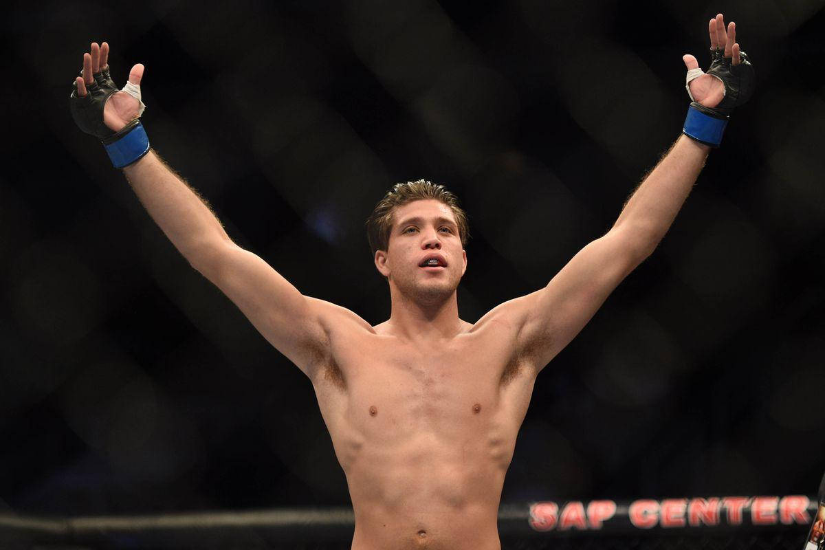 MMA選手在八角籠中高舉雙臂慶祝勝利。