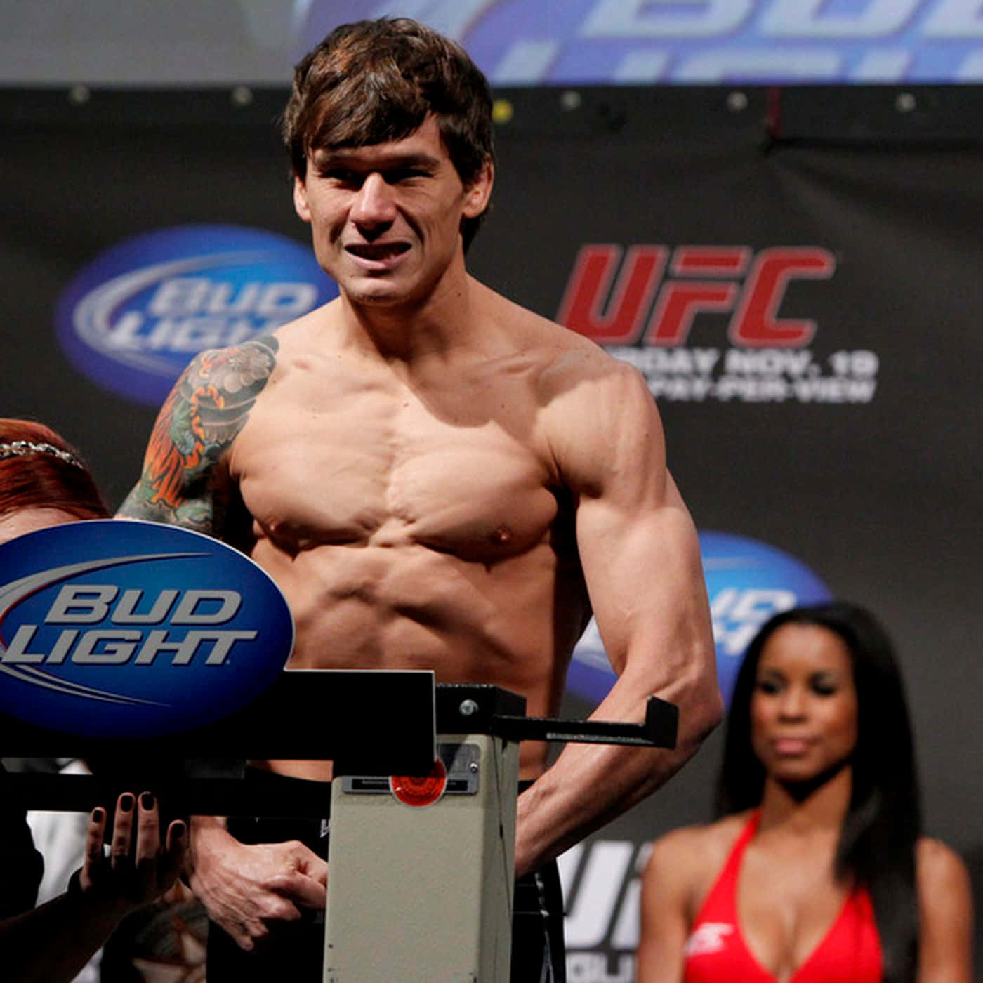 布萊恩·鮑爾斯為UFC 160 2013賽事做準備 壁紙 — 一位肌肉發達、手臂有紋身的UFC拳手，在Bud Light和UFC品牌的過磅活動中赤裸上身站在磅秤上。