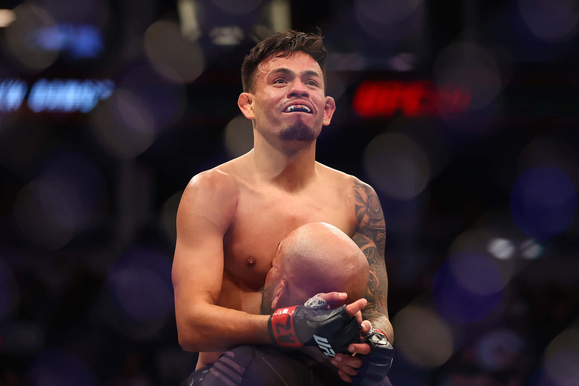 MMA拳手在競技場擁抱對手慶祝勝利