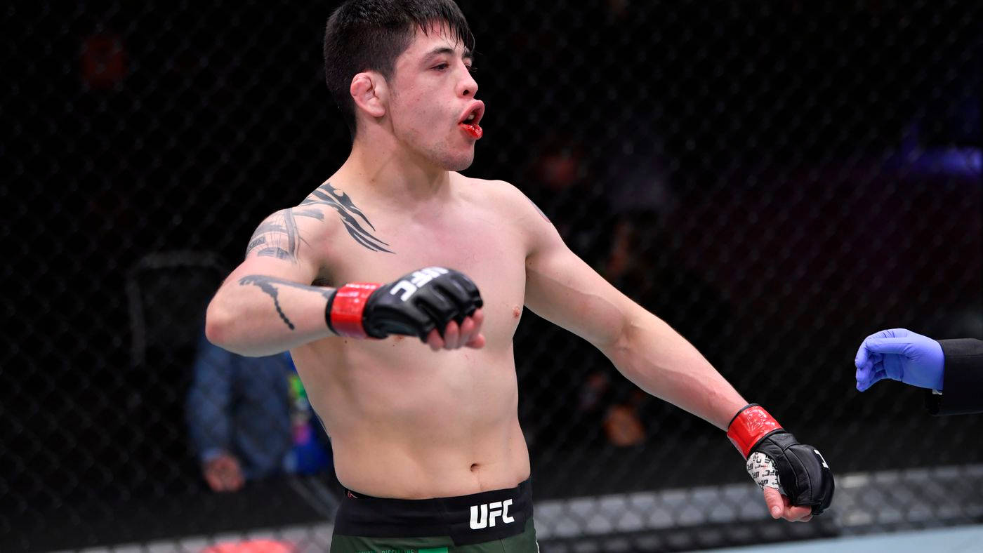 MMA拳手在UFC八角籠內嘴唇帶血慶祝勝利。
