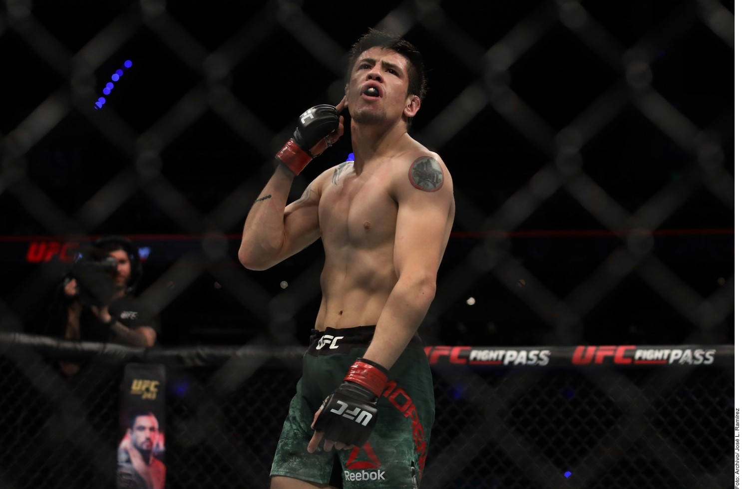 MMA拳手在UFC八角籠內張開嘴巴舉起手慶祝勝利。