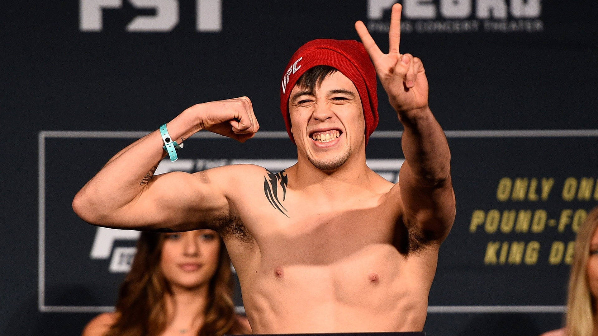 UFC拳手在稱重活動中繃緊肌肉並微笑