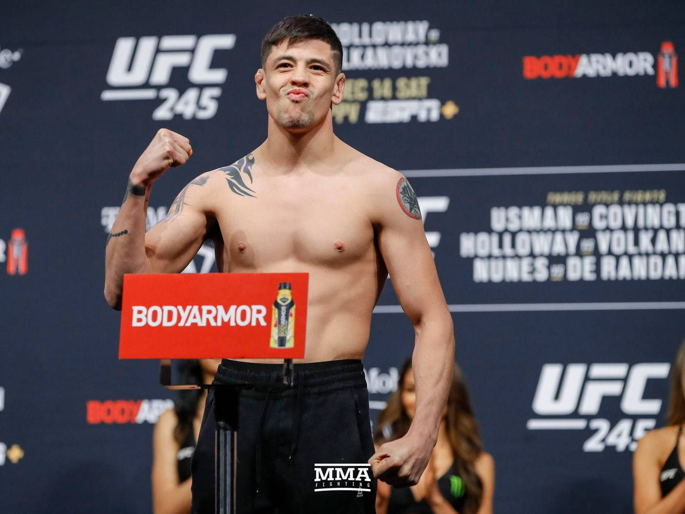 UFC拳手赤裸上身與BodyArmor標誌在稱重時擺姿勢