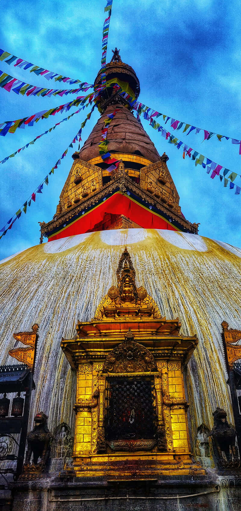 金色佛塔點綴著彩色經幡，襯著鮮豔藍天。