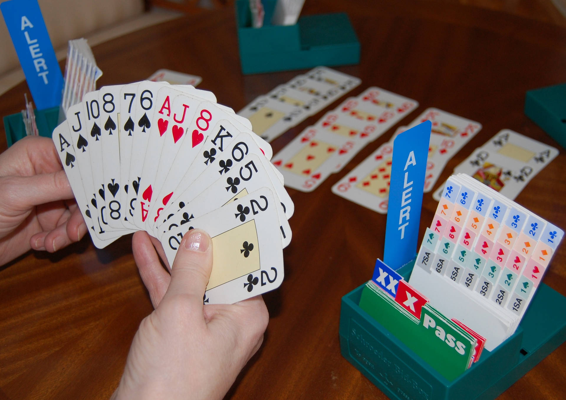在帶有綠色遊戲配件的卡牌遊戲中，雙手拿著撲克牌。