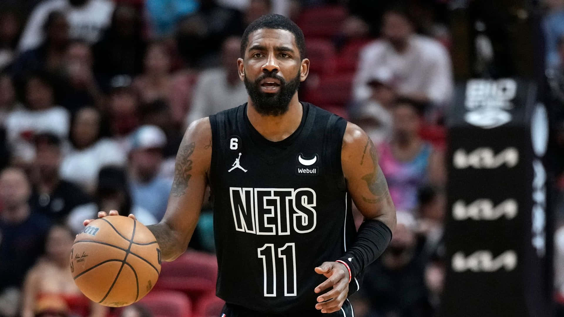 身穿黑色Nets球衣的籃球運動員在比賽中運球。