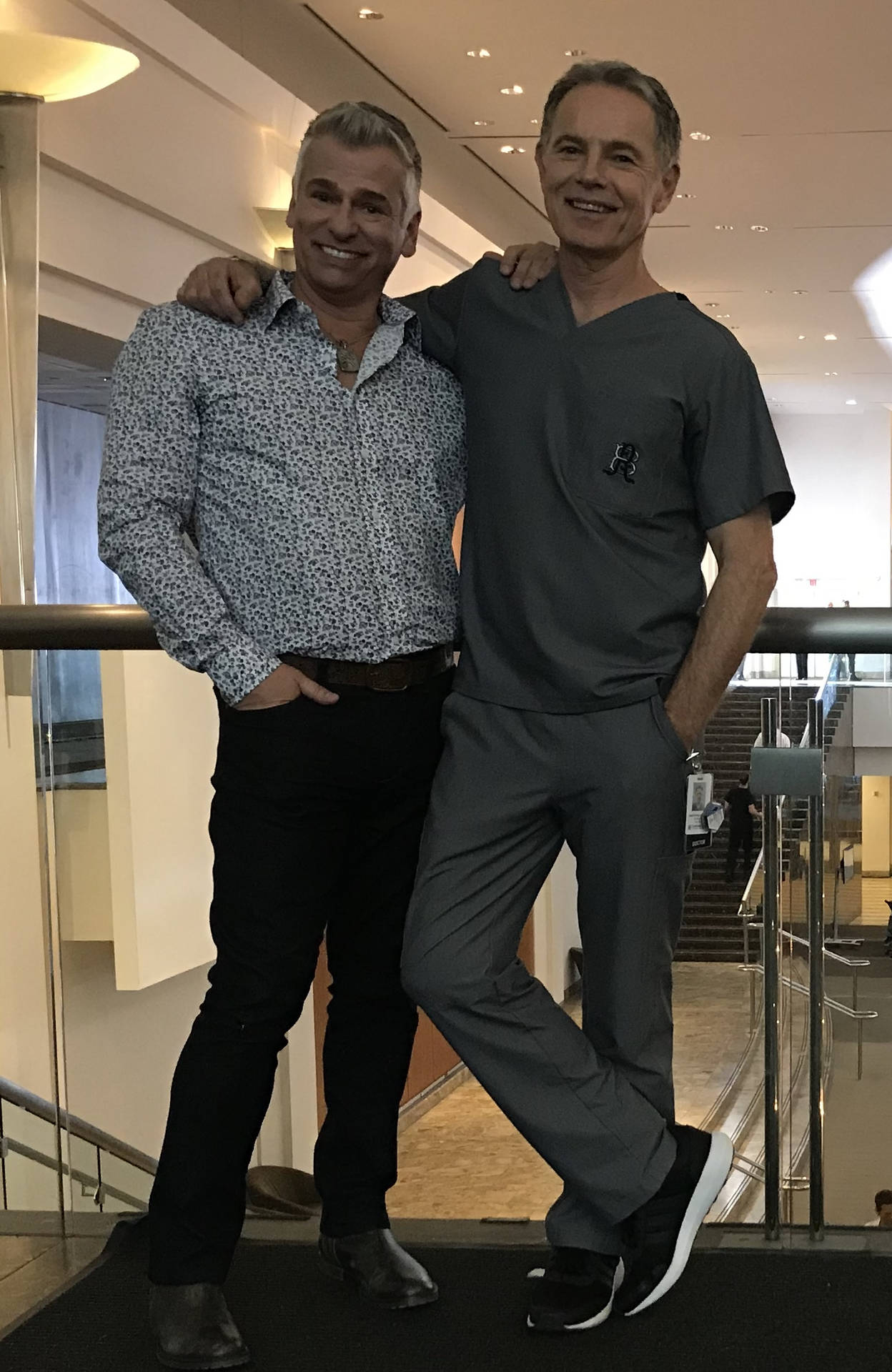 兩名男子在室內互相搭肩合影。