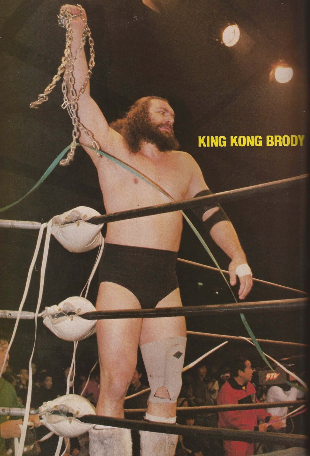 摔角手King Kong Brody在擂台上舉起鐵鏈慶祝勝利。