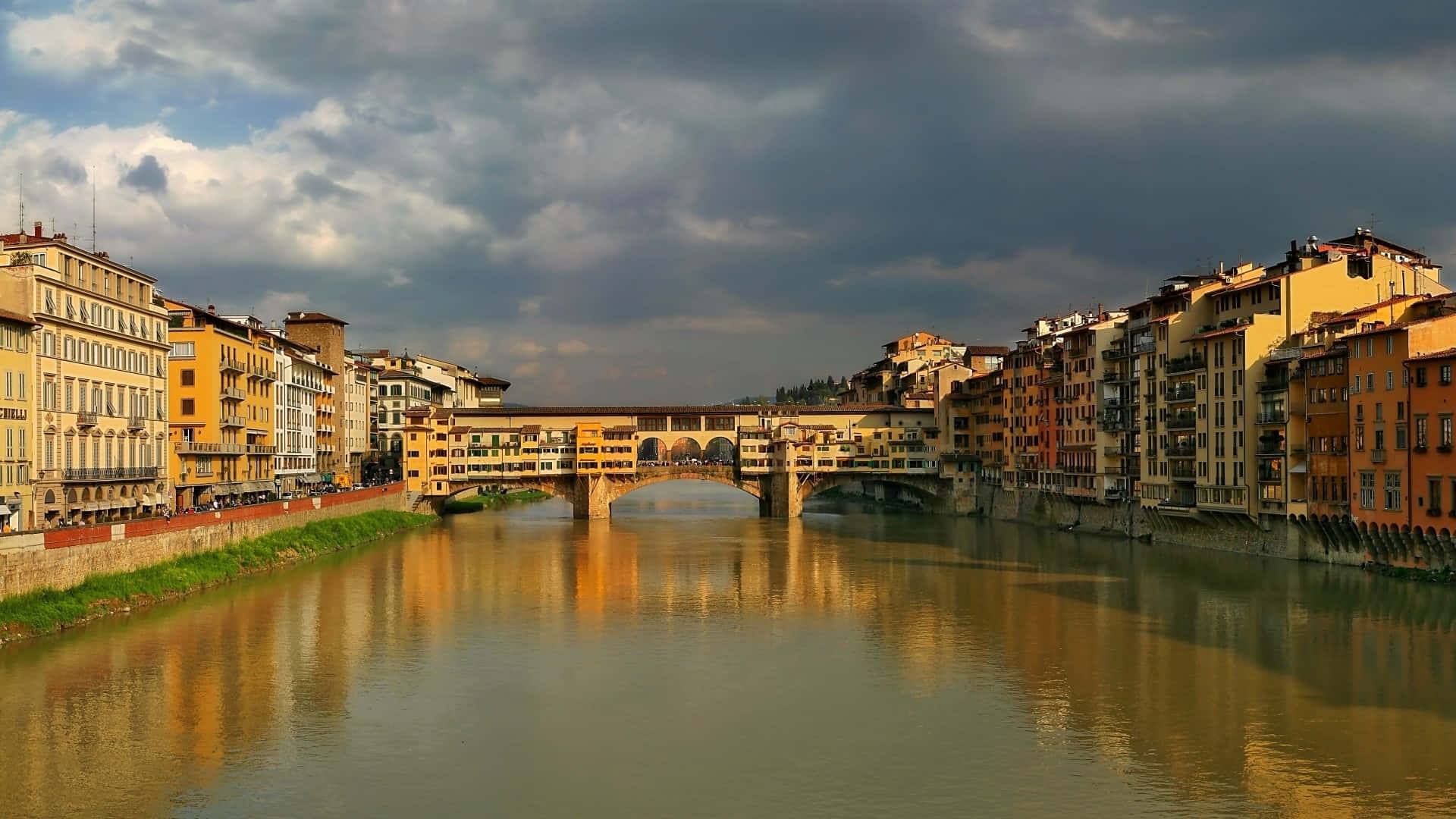 希臘大陸彭特維喬橋 壁紙 — Ponte Vecchio橋橫跨阿諾河，在戲劇性的多雲天空下，歷史建築倒映在水中。