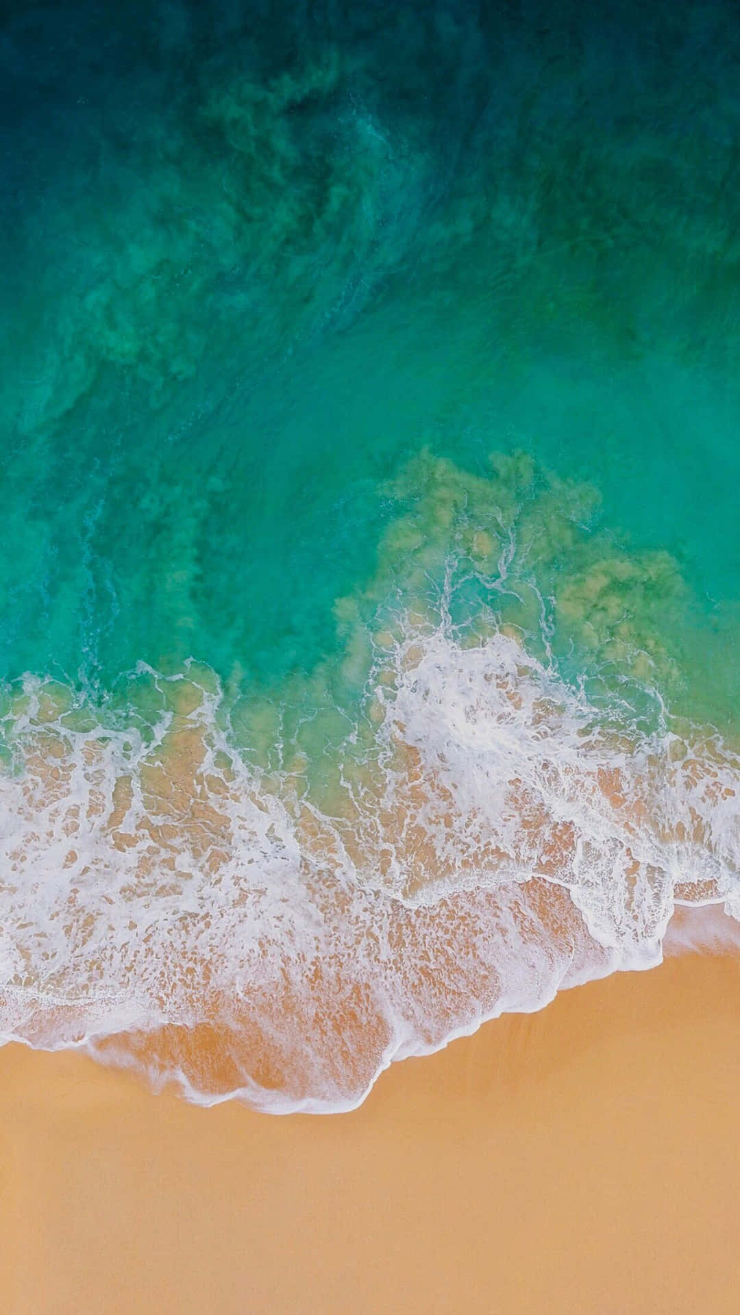 綠松石色的海浪從上方沖刷金色沙灘。
