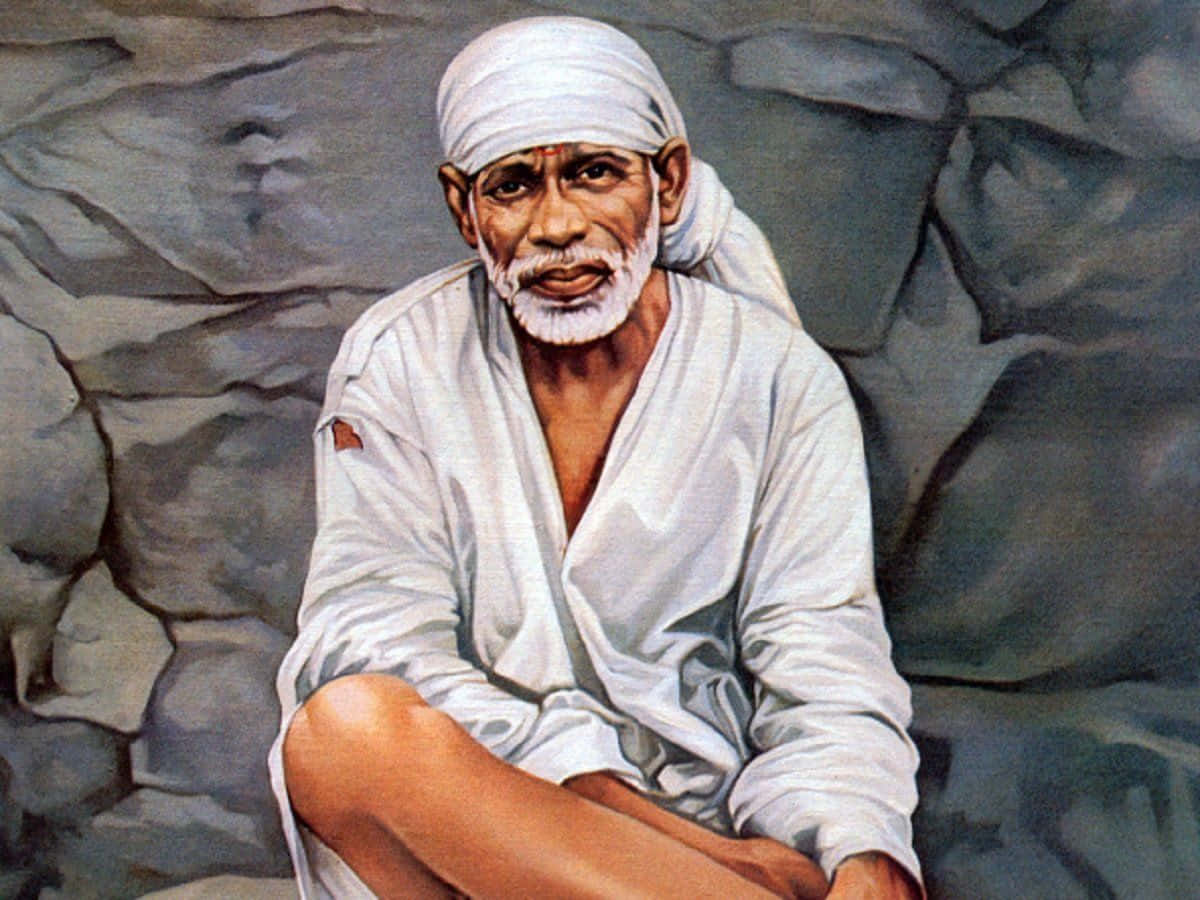 希迪 Sai Baba 穿白衣肖像 壁紙 — 一位留著白鬍子、戴著頭巾的長者，靠著灰色石牆平靜地坐著，構成一幅寧靜的肖像。