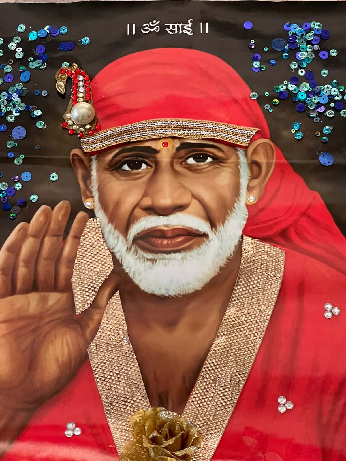 希迪 Sai Baba 穿紅衣畫像 壁紙 — 一幅充滿活力的賽巴巴肖像，身穿紅色服飾，飾有金色裝飾和藍色亮片，背景為深色。