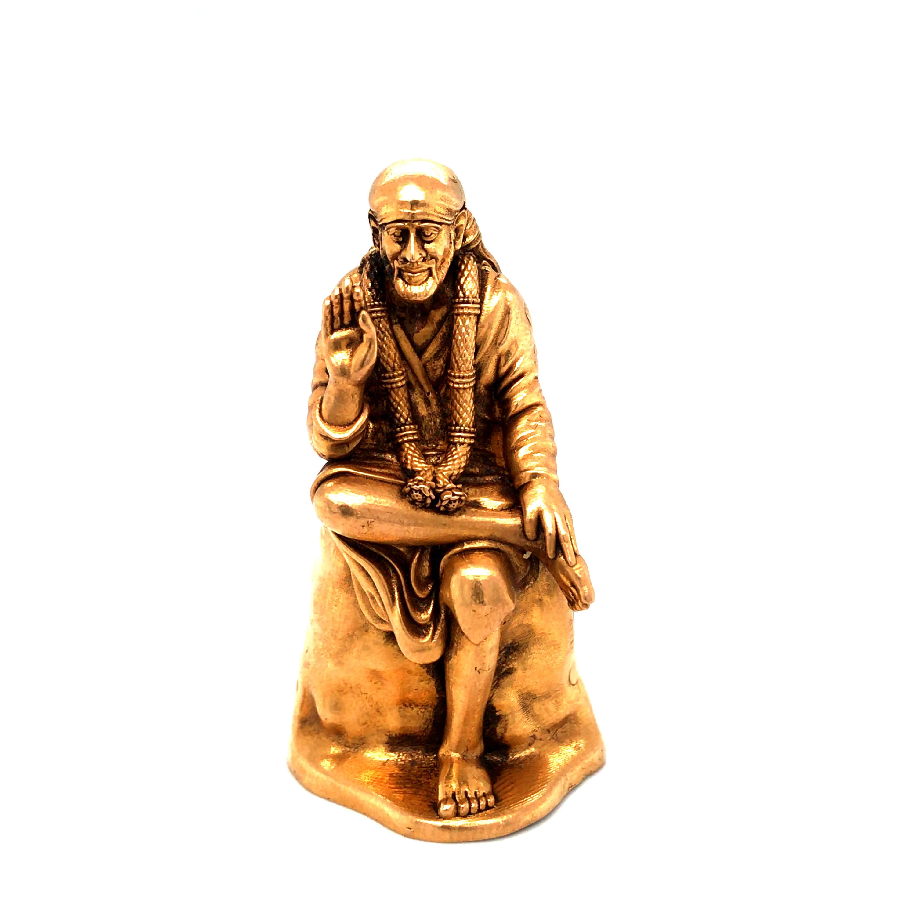 希迪 Sai Baba 金屬雕像肖像 壁紙 — 金色坐姿智者雕像，表情祥和，手勢抬起，背景為純白色。