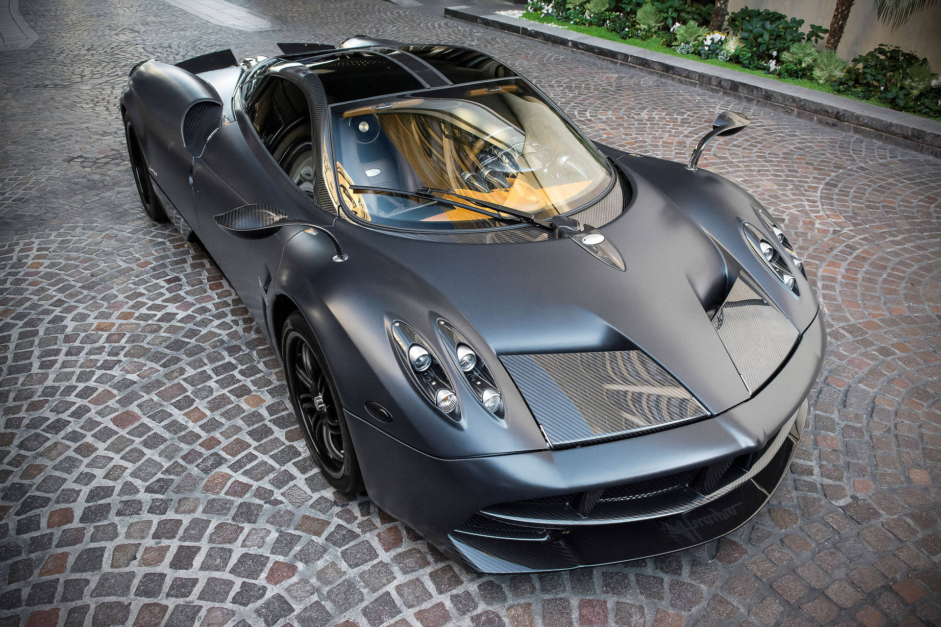 啞光黑色帕加尼 Huayra 跑車在鵝卵石車道上
