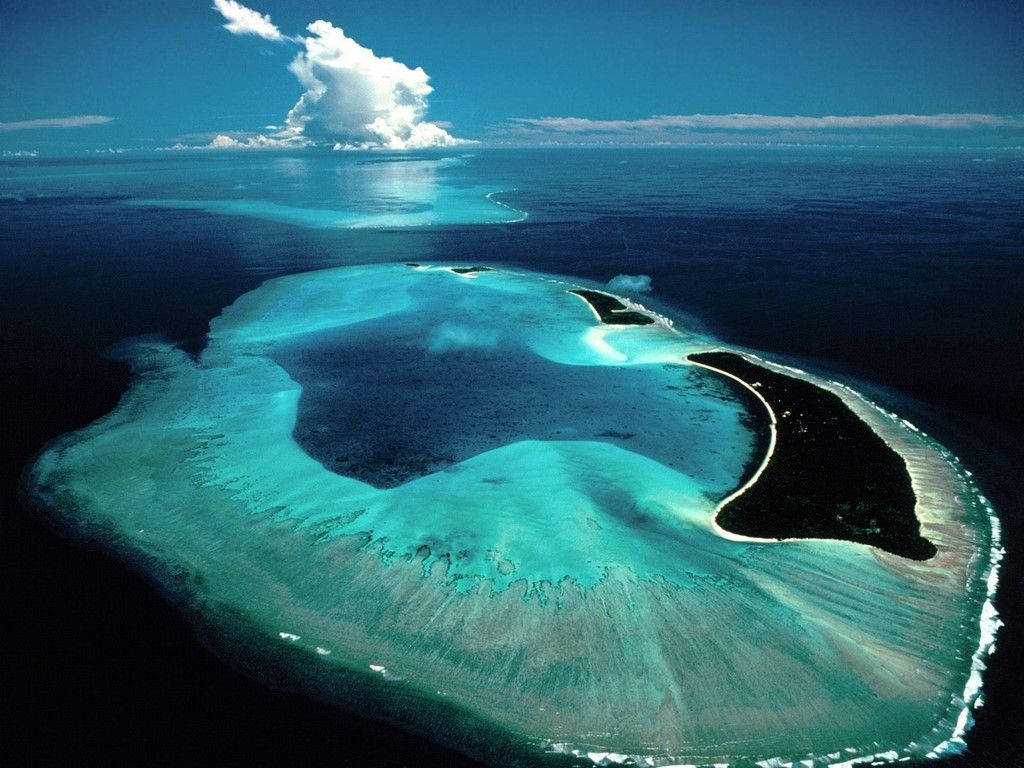 帕勞凱安格爾環礁 壁紙 — 喺明亮天空下，一個壯麗環礁嘅航拍圖，有藍綠色潟湖，被深藍色海洋同白色沙灘包圍。