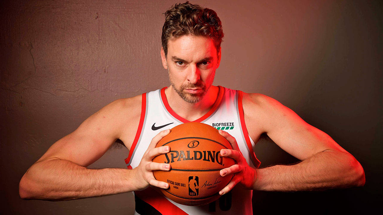 運動型籃球運動員在紅色燈光的攝影棚中拿著 Spalding 球。