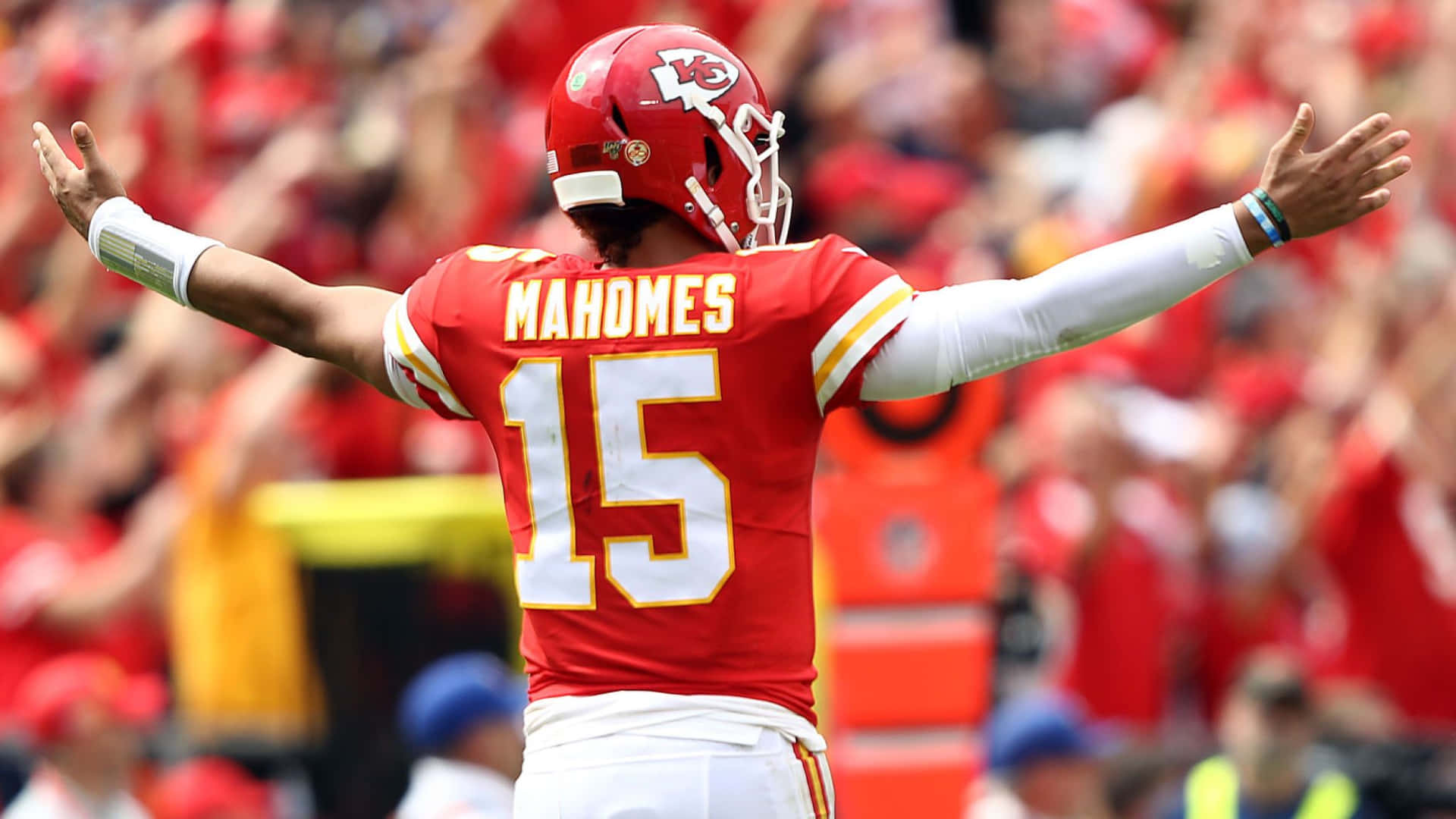 足球四分衛 Patrick Mahomes 在球場上張開雙臂慶祝。