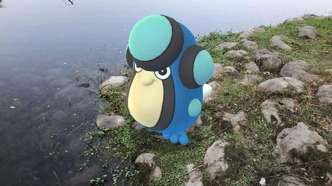 帕路奇亞出現在Pokémon GO中 壁紙 — 一隻大型藍色和藍綠色卡通企鵝站在一個平靜的湖邊，周圍有岩石和綠草。