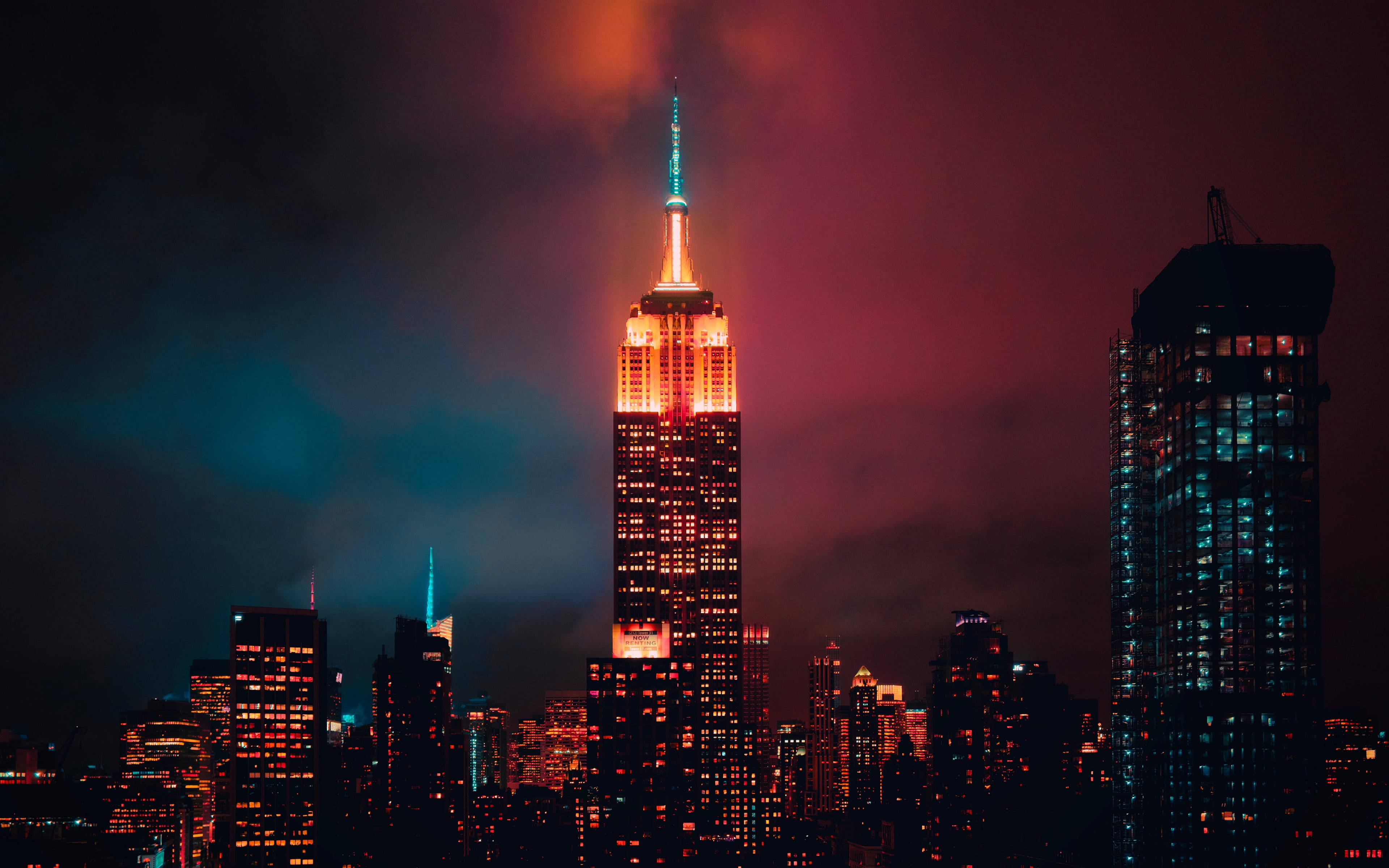 new york 4K 桌布 壁紙 — 帝國大廈在佈滿洋紅色和藍綠色雲彩的戲劇性暮色天空中溫暖地發光。