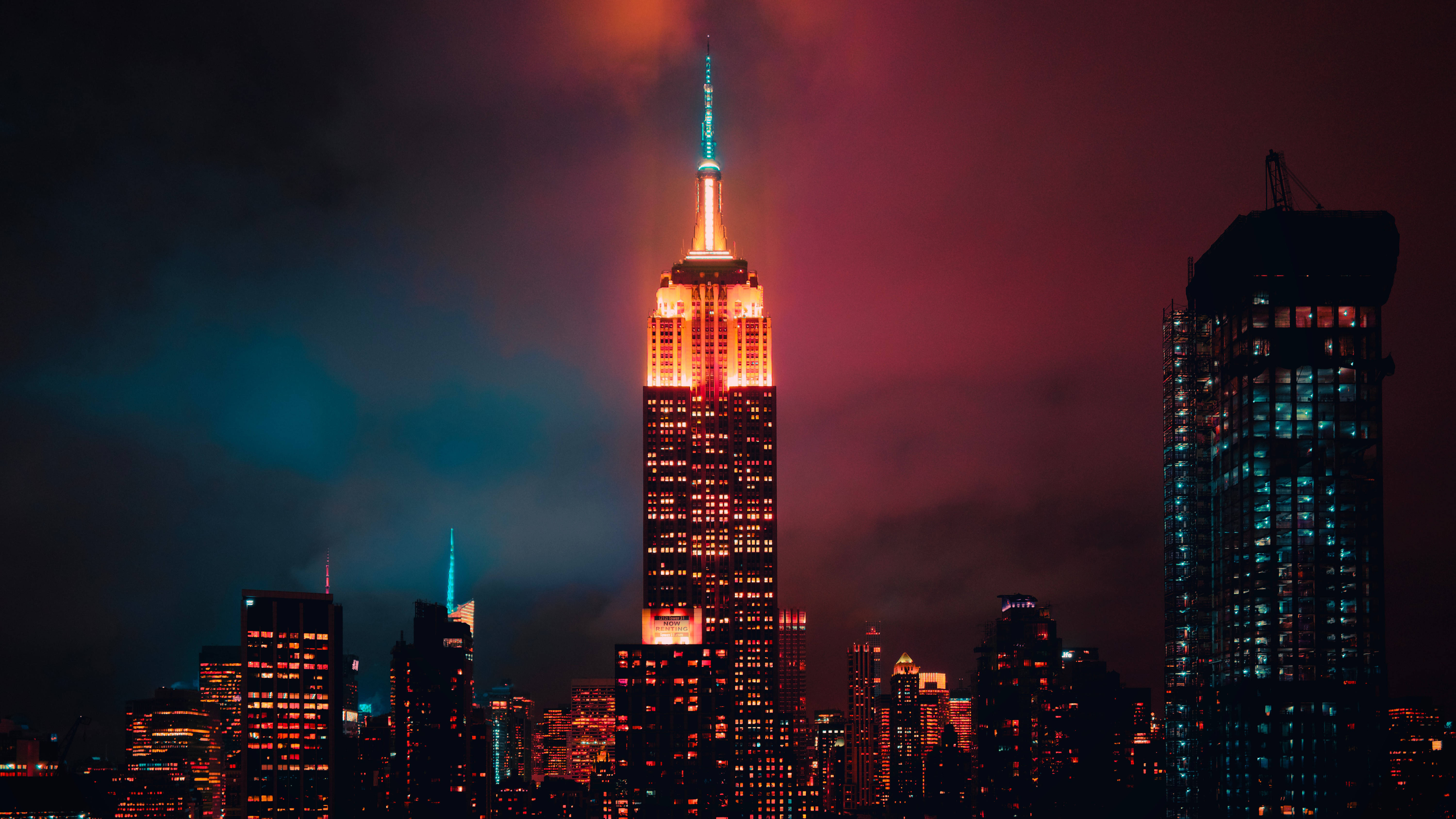 帝國大廈夜景 壁紙 — 帝國大廈在琥珀色和藍綠色的光芒中，映襯著帶有洋紅色和藍綠色雲彩的戲劇性暮色天空。